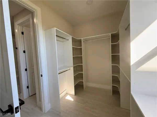 a view of walk in closet with empty racks