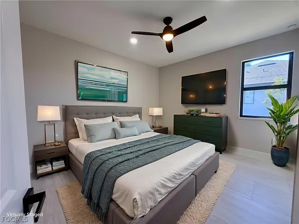 a spacious bedroom with a bed and a flat screen tv