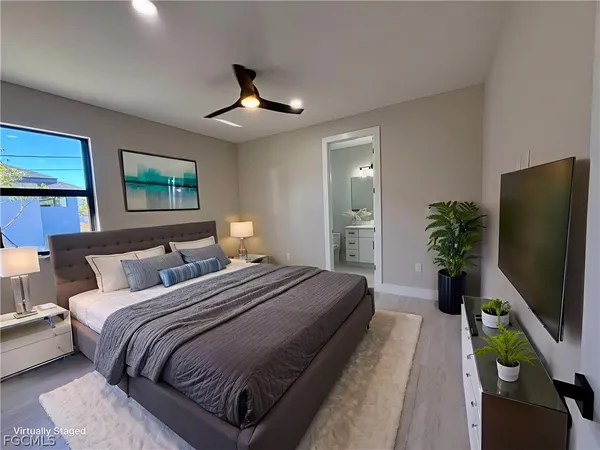 a bedroom with bed tv and window