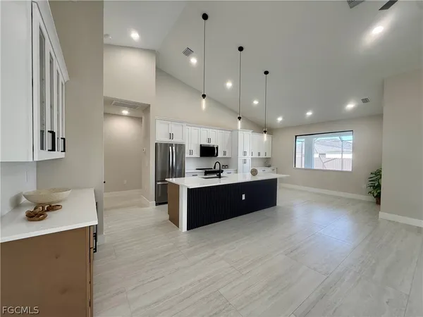a large kitchen with a large counter top appliances and cabinets