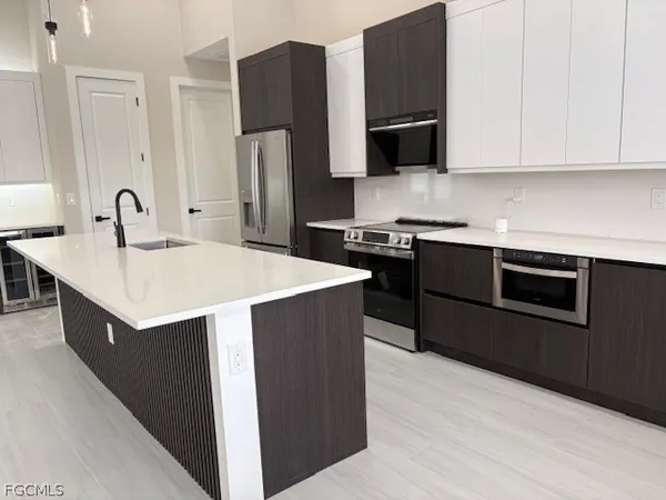 a kitchen with stainless steel appliances granite countertop a stove top oven microwave and refrigerator