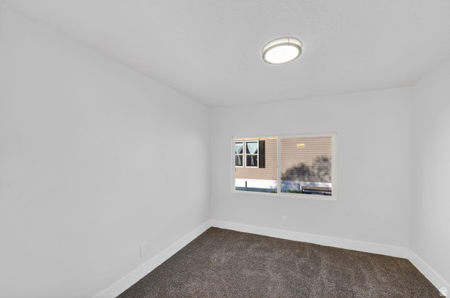2491 Highway 89, Unit 523 Pleasant View, UT 84404 - Photo 14 of 31 Spare room featuring dark carpet and baseboards