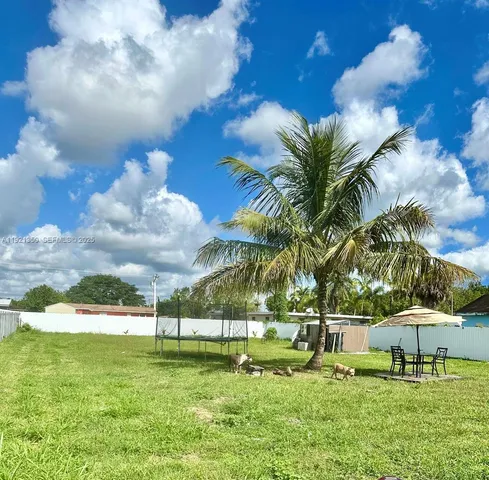 a backyard of a house with table and chairs