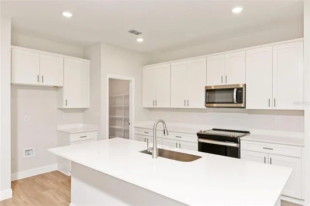 a kitchen with stainless steel appliances a stove microwave and sink