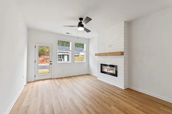 an empty room with windows and fireplace