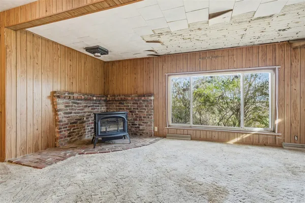 a view of an empty room with a fireplace and a window