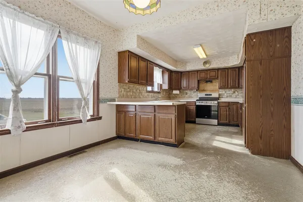 a kitchen with stainless steel appliances granite countertop a stove top oven a sink dishwasher and a refrigerator