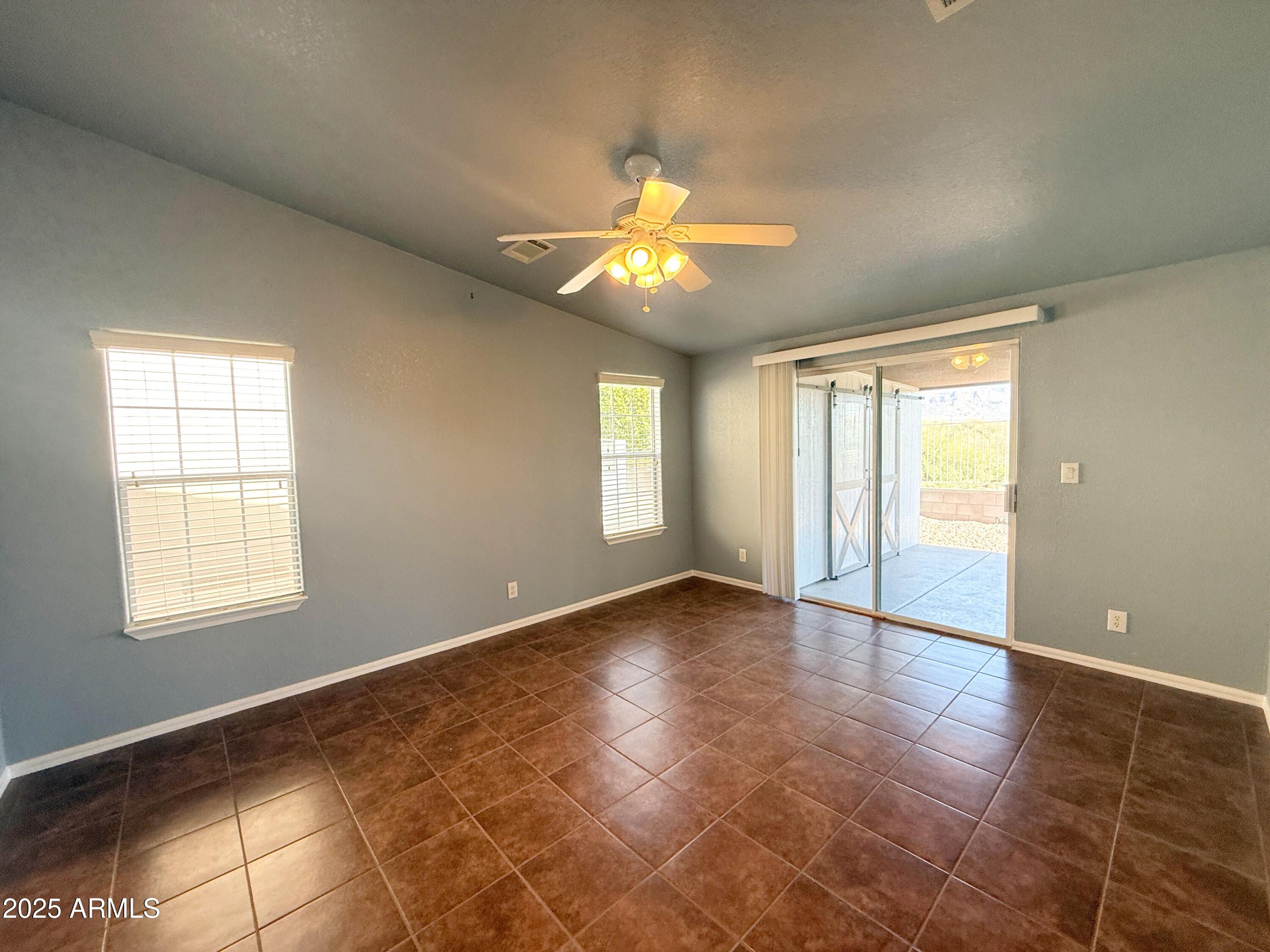 3301 South Goldfield Road, Unit 5078 Apache Junction, AZ 85119 - Photo 11 of 46 a view of an empty room with window and chandelier fan