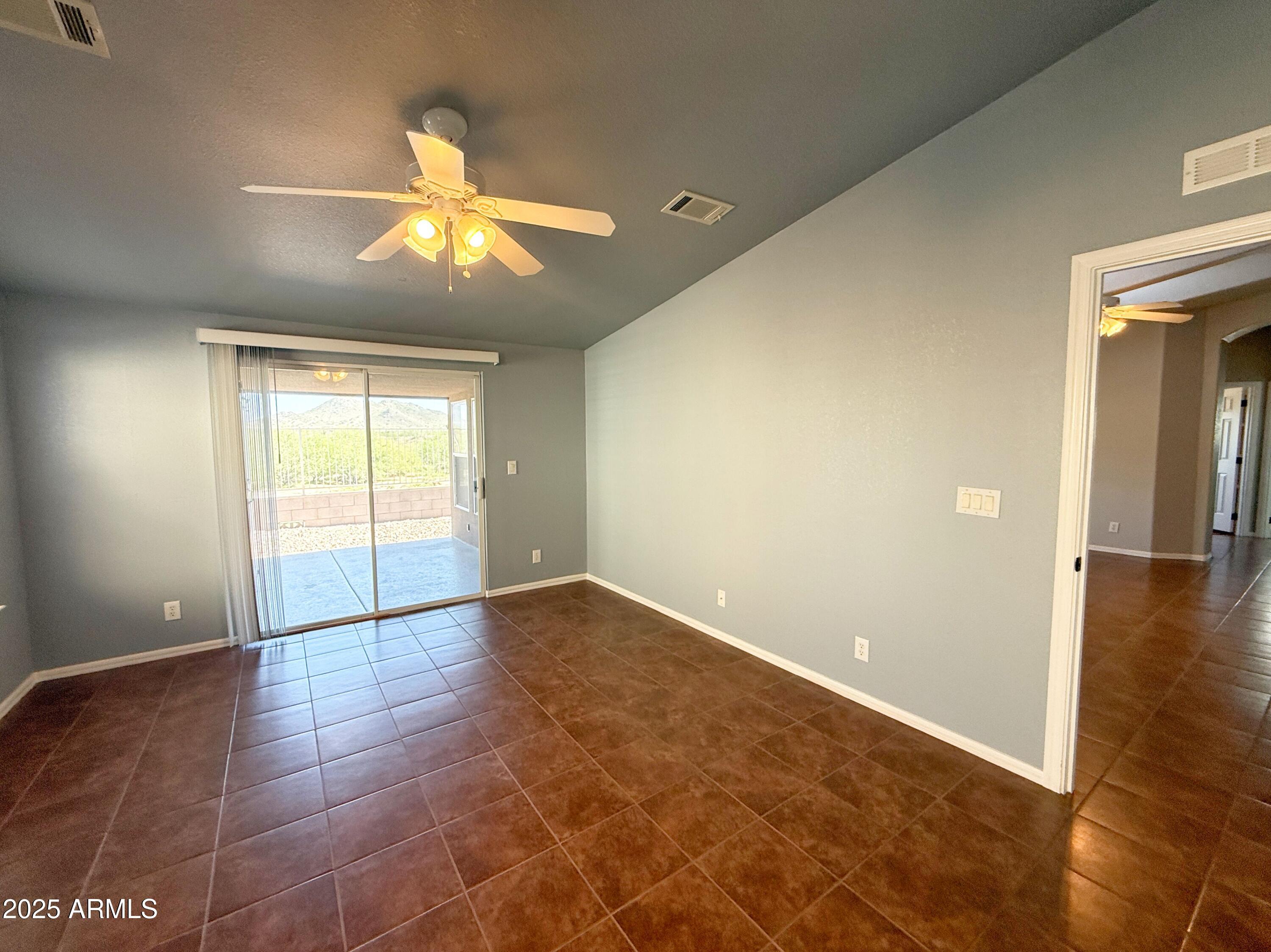 3301 South Goldfield Road, Unit 5078 Apache Junction, AZ 85119 - Photo 12 of 46 a view of an empty room and window and chandelier fan