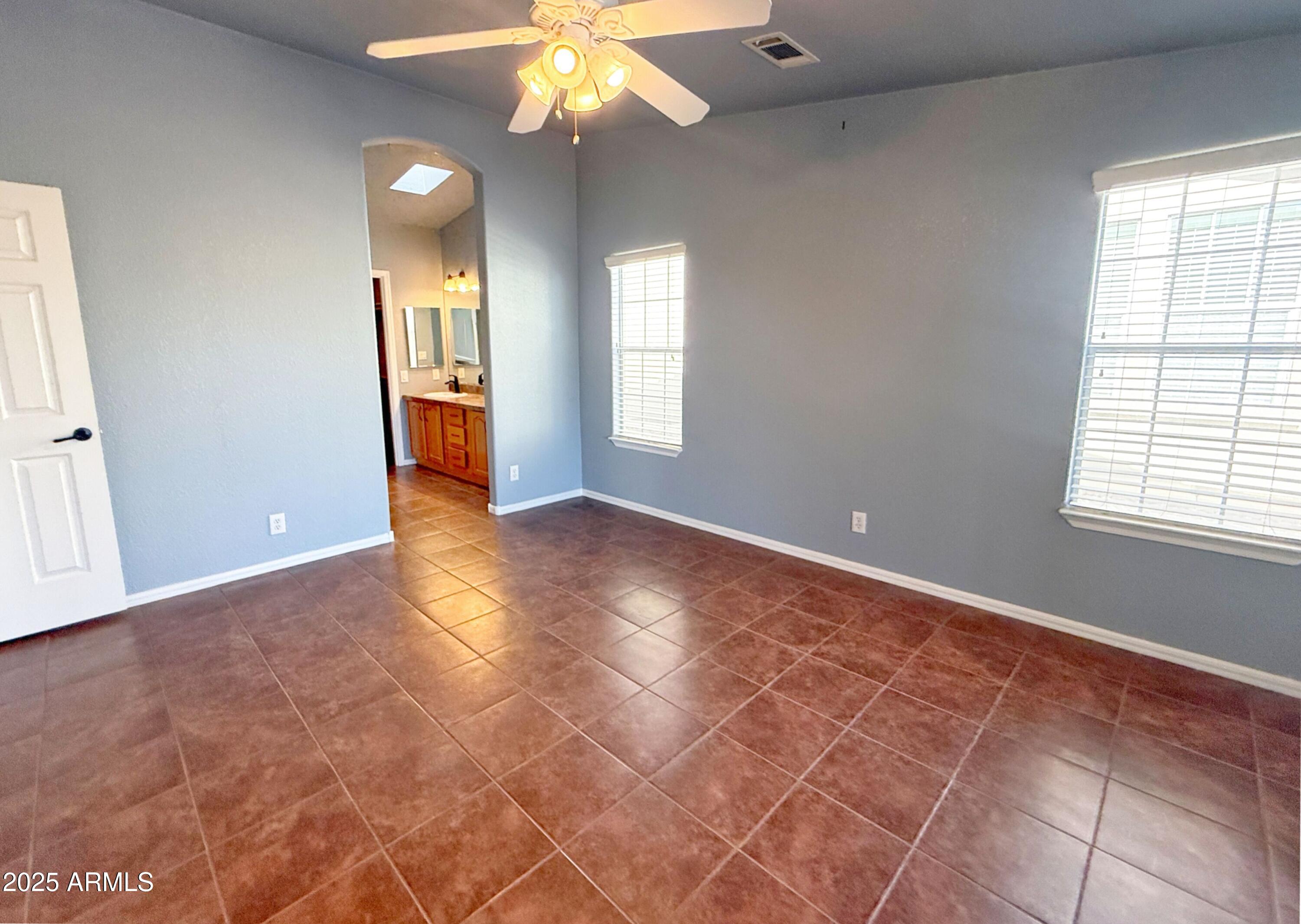 3301 South Goldfield Road, Unit 5078 Apache Junction, AZ 85119 - Photo 13 of 46 an empty room with windows and chandelier fan