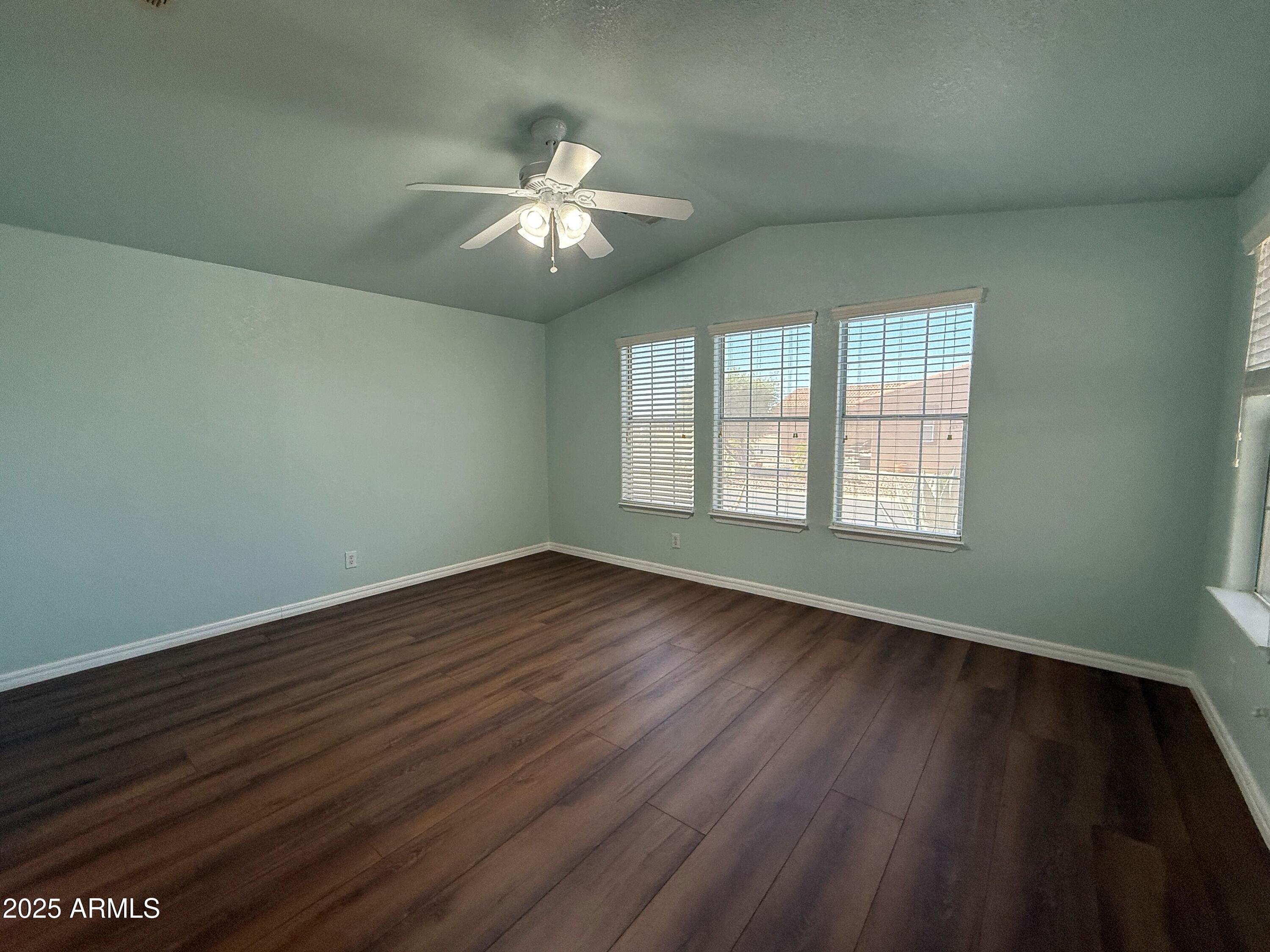 3301 South Goldfield Road, Unit 5078 Apache Junction, AZ 85119 - Photo 20 of 46 a view of an empty room with wooden floor and a window