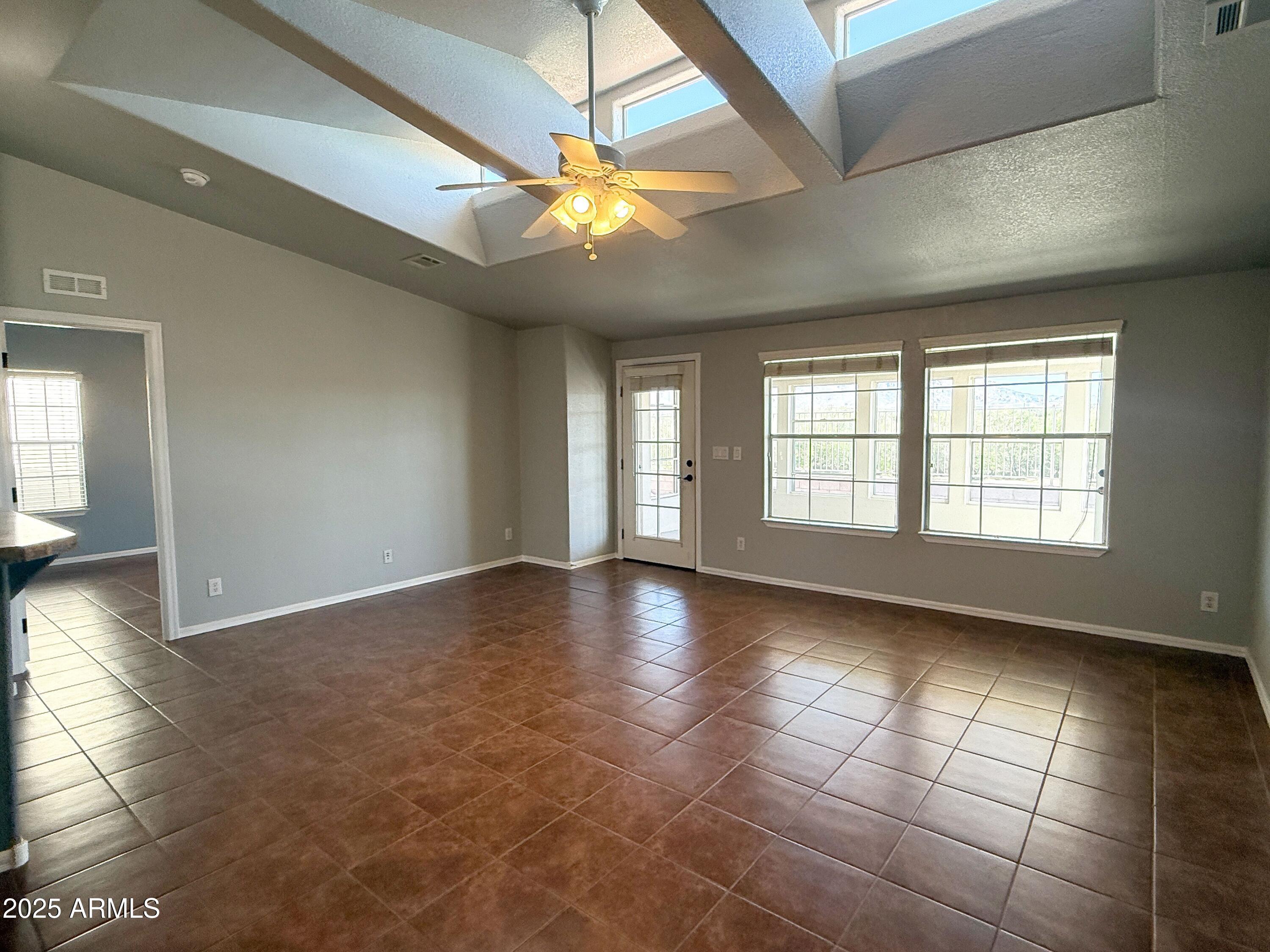 3301 South Goldfield Road, Unit 5078 Apache Junction, AZ 85119 - Photo 2 of 46 a view of an empty room with window and chandelier fan