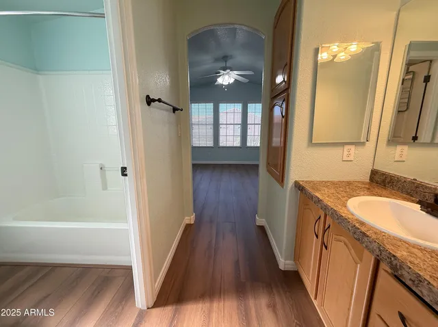 a bathroom with a granite countertop sink a mirror and shower