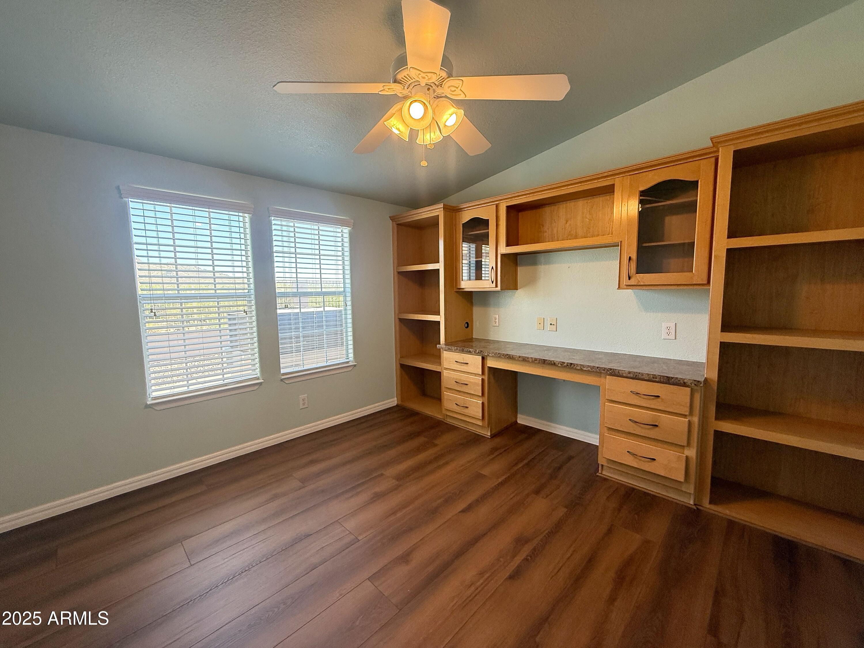 3301 South Goldfield Road, Unit 5078 Apache Junction, AZ 85119 - Photo 28 of 46 a view of an empty room with a window and wooden floor