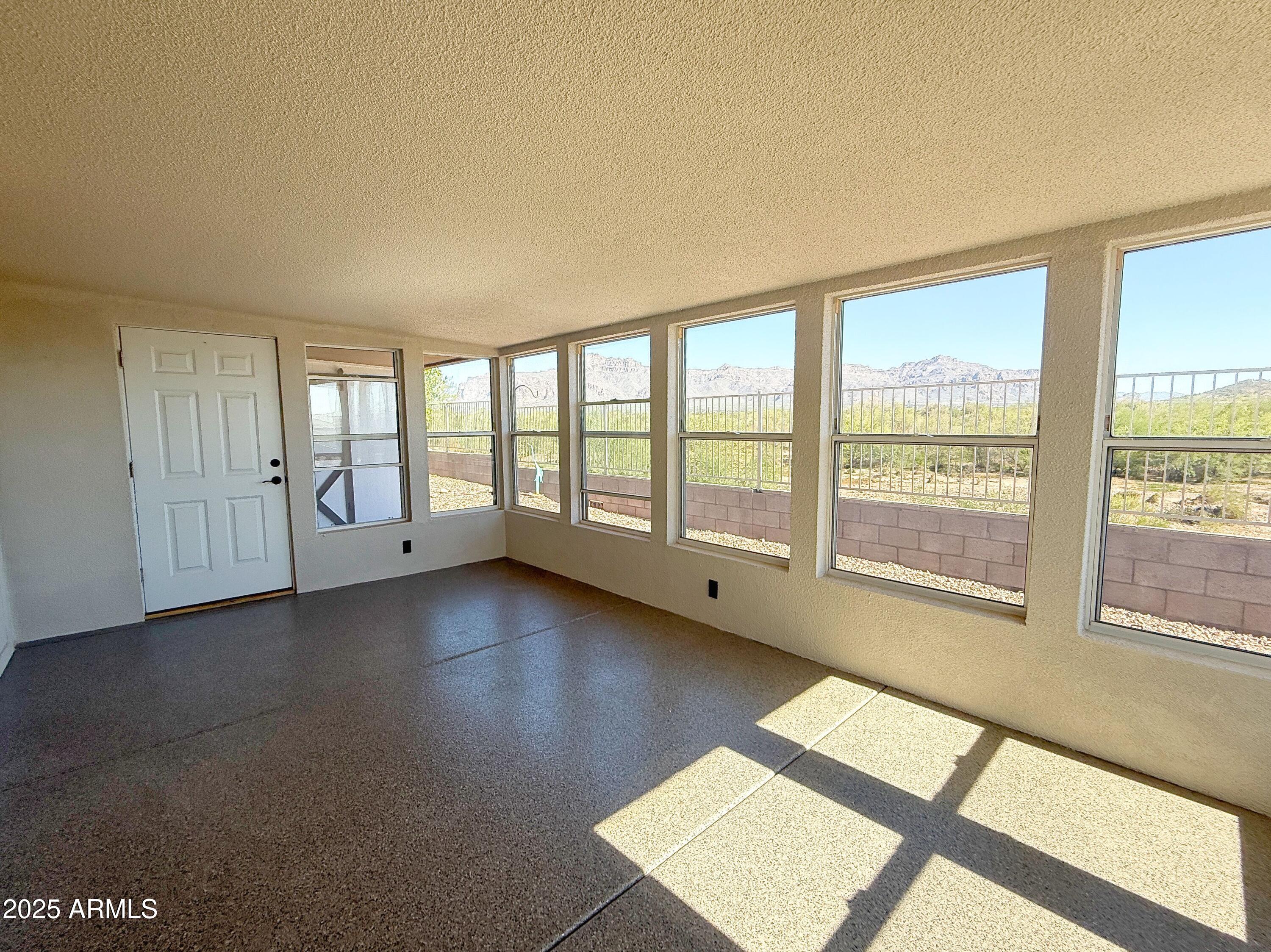 3301 South Goldfield Road, Unit 5078 Apache Junction, AZ 85119 - Photo 34 of 46 a view of an empty room with large windows
