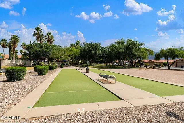 a view of swimming pool with outdoor seating and trees in the background