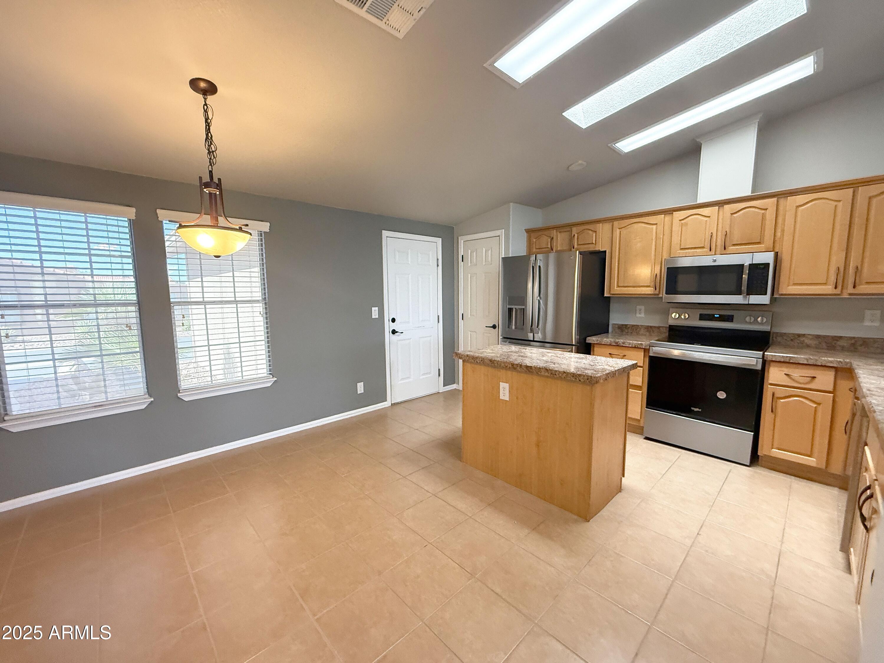 3301 South Goldfield Road, Unit 5078 Apache Junction, AZ 85119 - Photo 6 of 46 a kitchen with kitchen island a counter top space appliances and a window