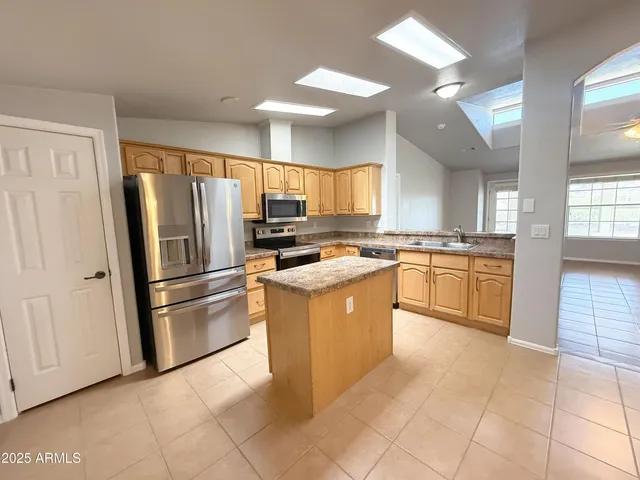 a kitchen with cabinets stainless steel appliances and a window