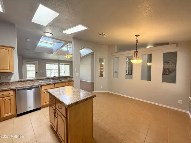 a kitchen with granite countertop a sink and dishwasher with a dining table