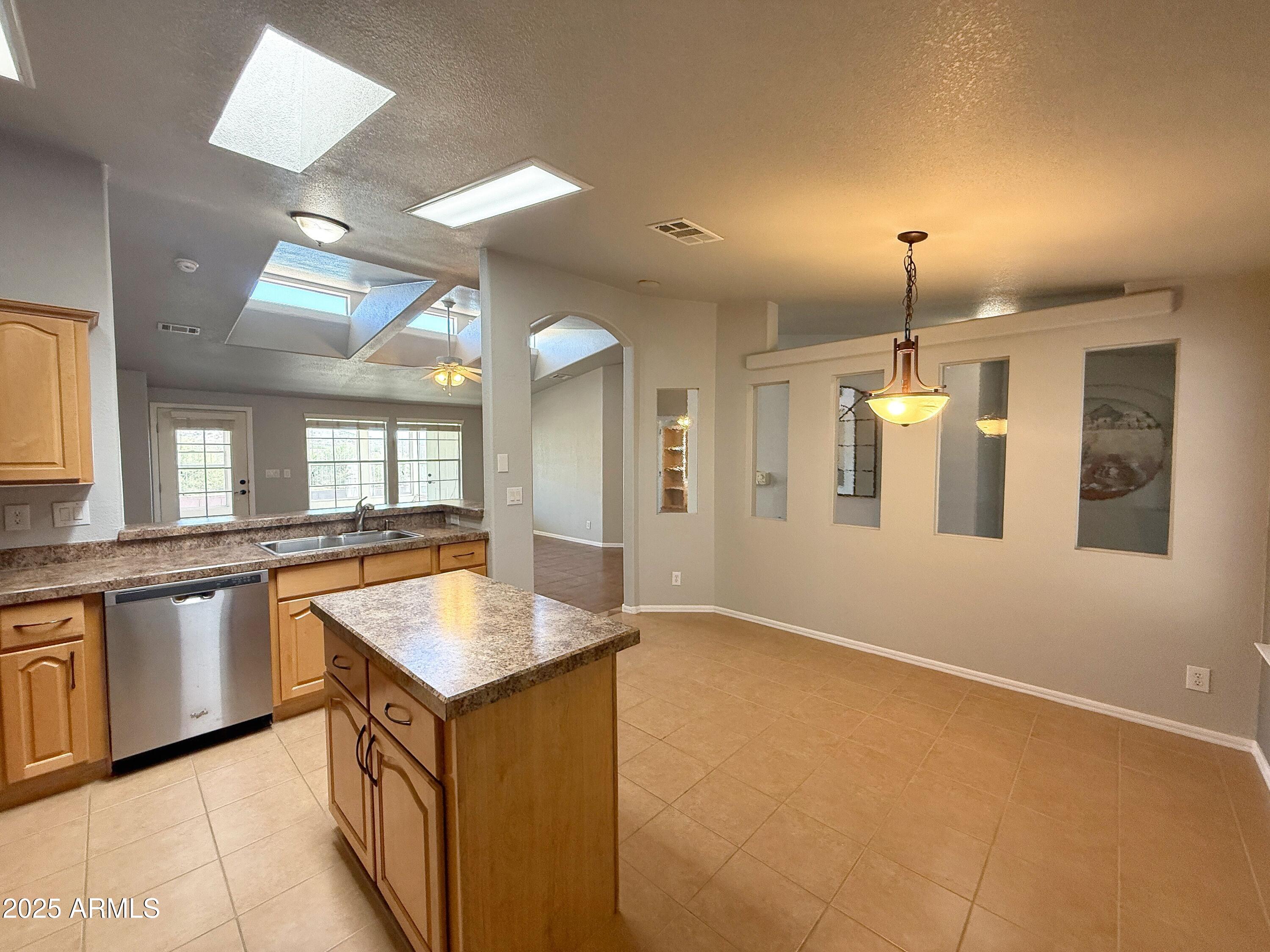3301 South Goldfield Road, Unit 5078 Apache Junction, AZ 85119 - Photo 8 of 46 a kitchen with granite countertop a sink and dishwasher with a dining table