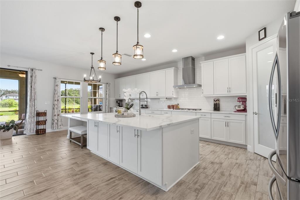 12970 Steed Trce Loop Lithia, FL 33547 - Photo 11 of 57 a large white kitchen with lots of counter space a sink appliances and cabinets