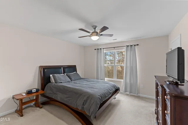 a bedroom with a large bed and a flat tv screen on a dresser
