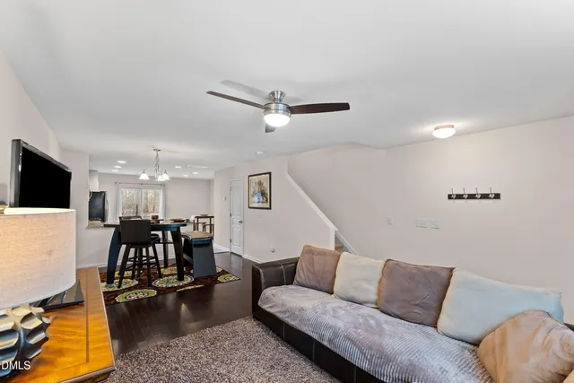 a living room with furniture and a flat screen tv with kitchen view