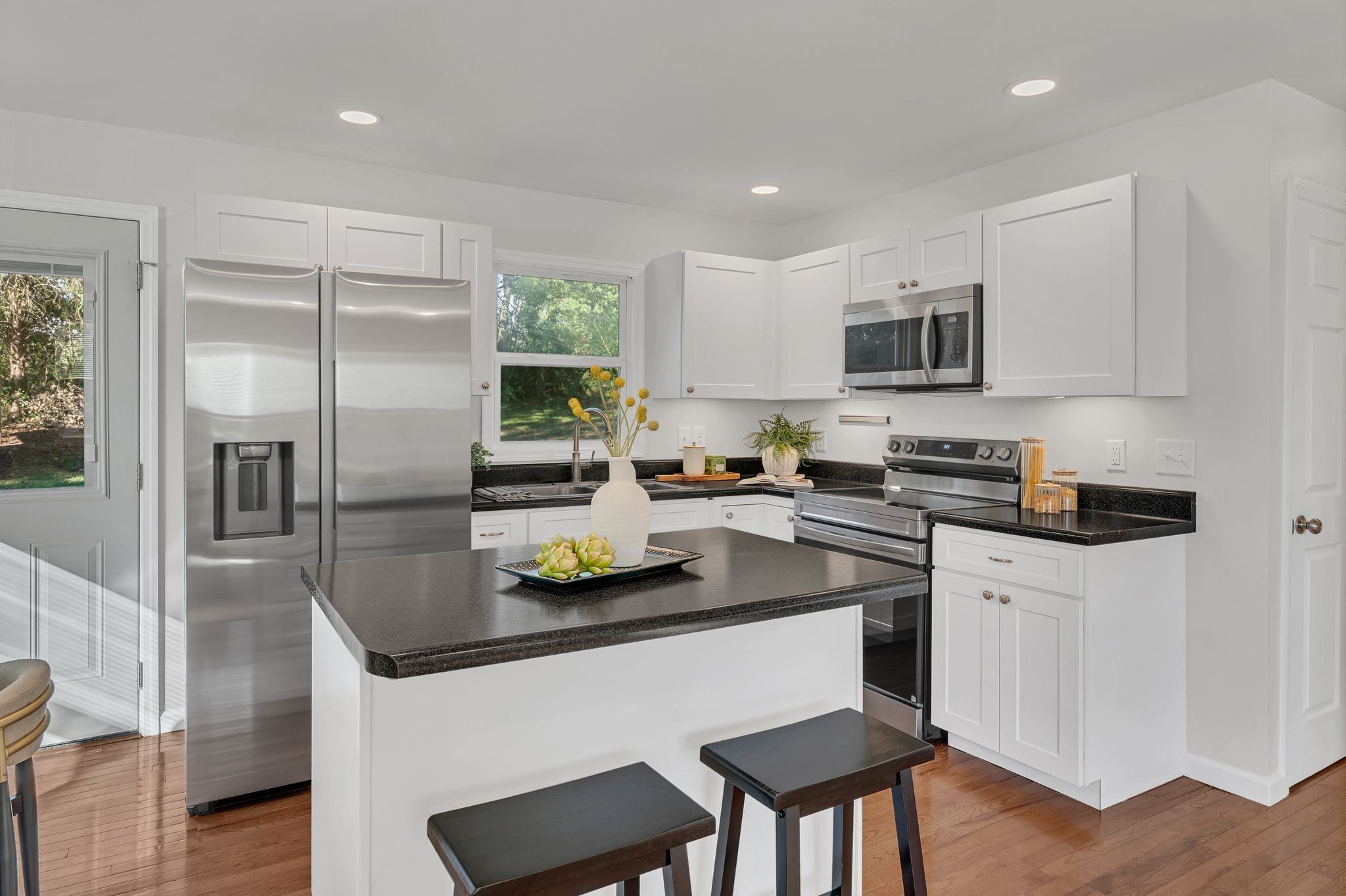 44 Flint Drive Decherd, TN 37324 - Photo 8 of 31 a kitchen with stainless steel appliances granite countertop a sink a stove a refrigerator cabinets and a dining table with wooden floor