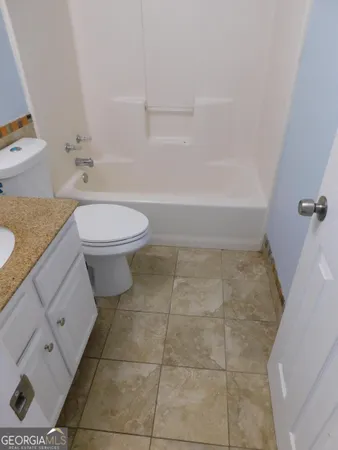 a bathroom with a granite countertop bathtub and toilet