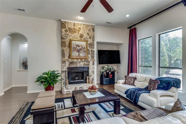 a living room with furniture a flat screen tv and a large window