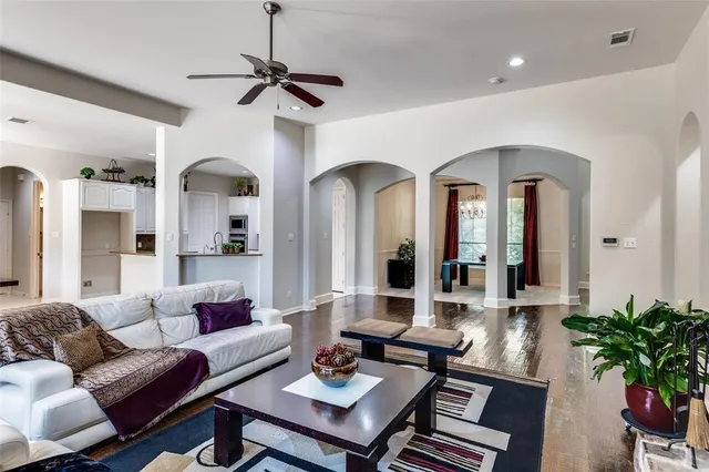 a living room with furniture a chandelier and a potted plant