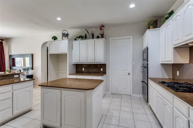 a kitchen with granite countertop a sink stove and refrigerator