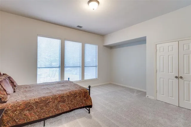 a spacious bedroom with a bed and a window