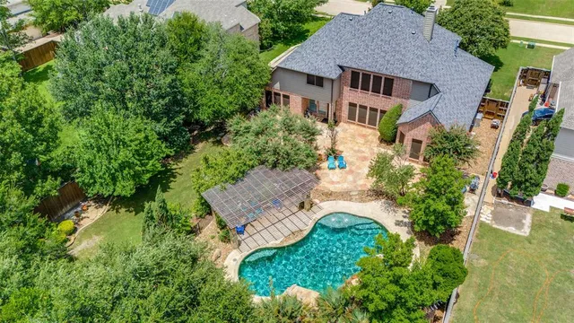 an aerial view of a house with yard and green space