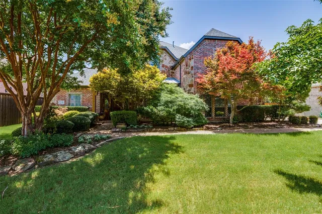 a front view of a house with a yard and trees