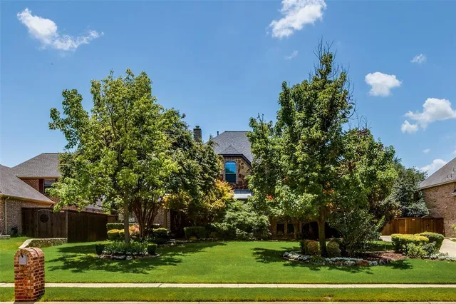 a front view of a house with a yard and a garden