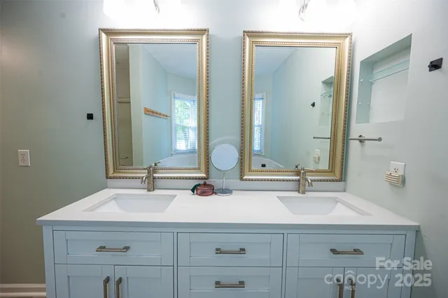 a bathroom with double vanity sink and a mirror