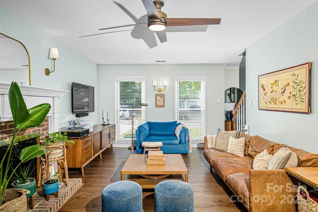 a living room with furniture a wooden floor and a flat screen tv