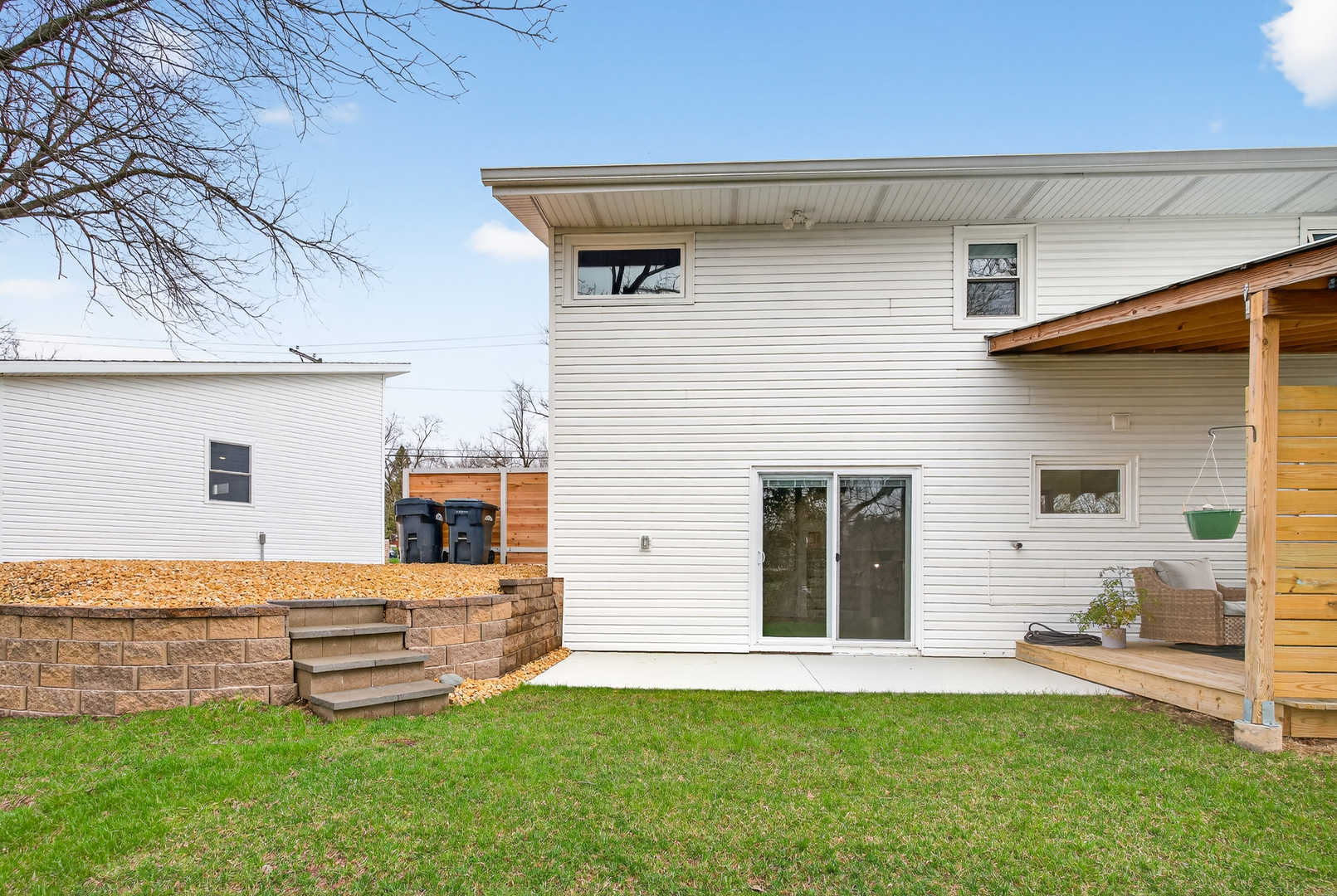 327 30th Avenue North Clinton, IA 52732 - Photo 36 of 38 a backyard of a white house with potted plants and a bench