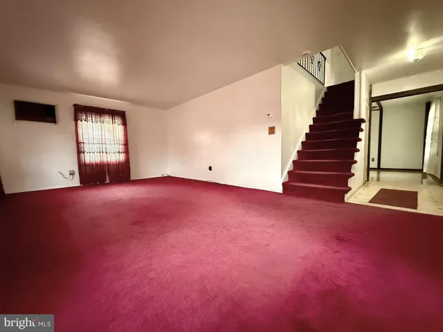 an empty room with windows and stairs