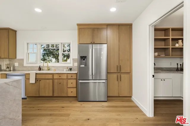 a kitchen with a refrigerator cabinets and wooden floor