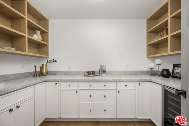 a kitchen with granite countertop white cabinets and window