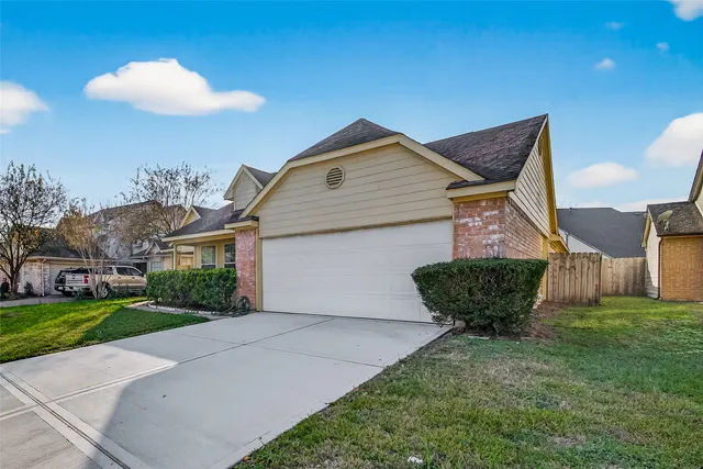 a front view of a house with a yard and potted plants