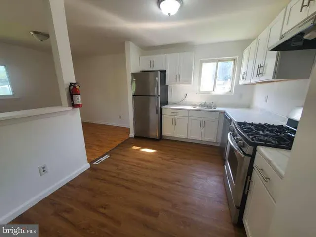 a kitchen with granite countertop a refrigerator and a sink