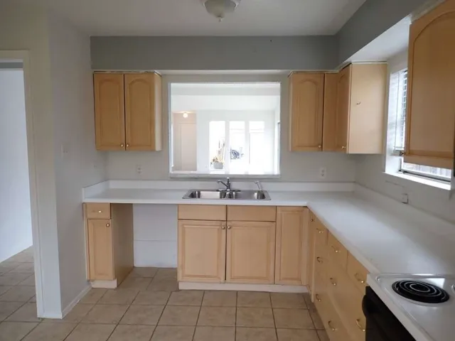 a kitchen with a sink cabinets and window