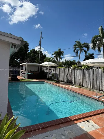a view of a backyard with wooden fence