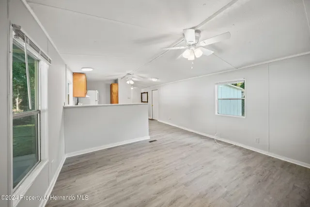 a view of a kitchen with wooden floor and a ceiling fan