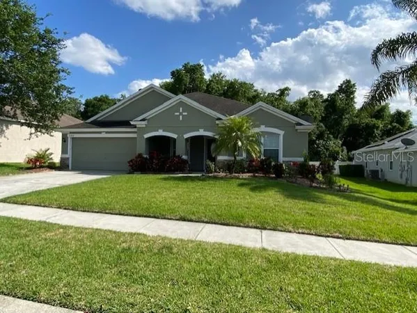 a front view of a house with a garden and yard