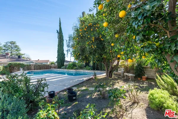 a backyard of a house with table and chairs under an umbrella