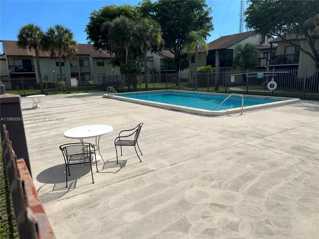 a view of a white house with a yard and furniture